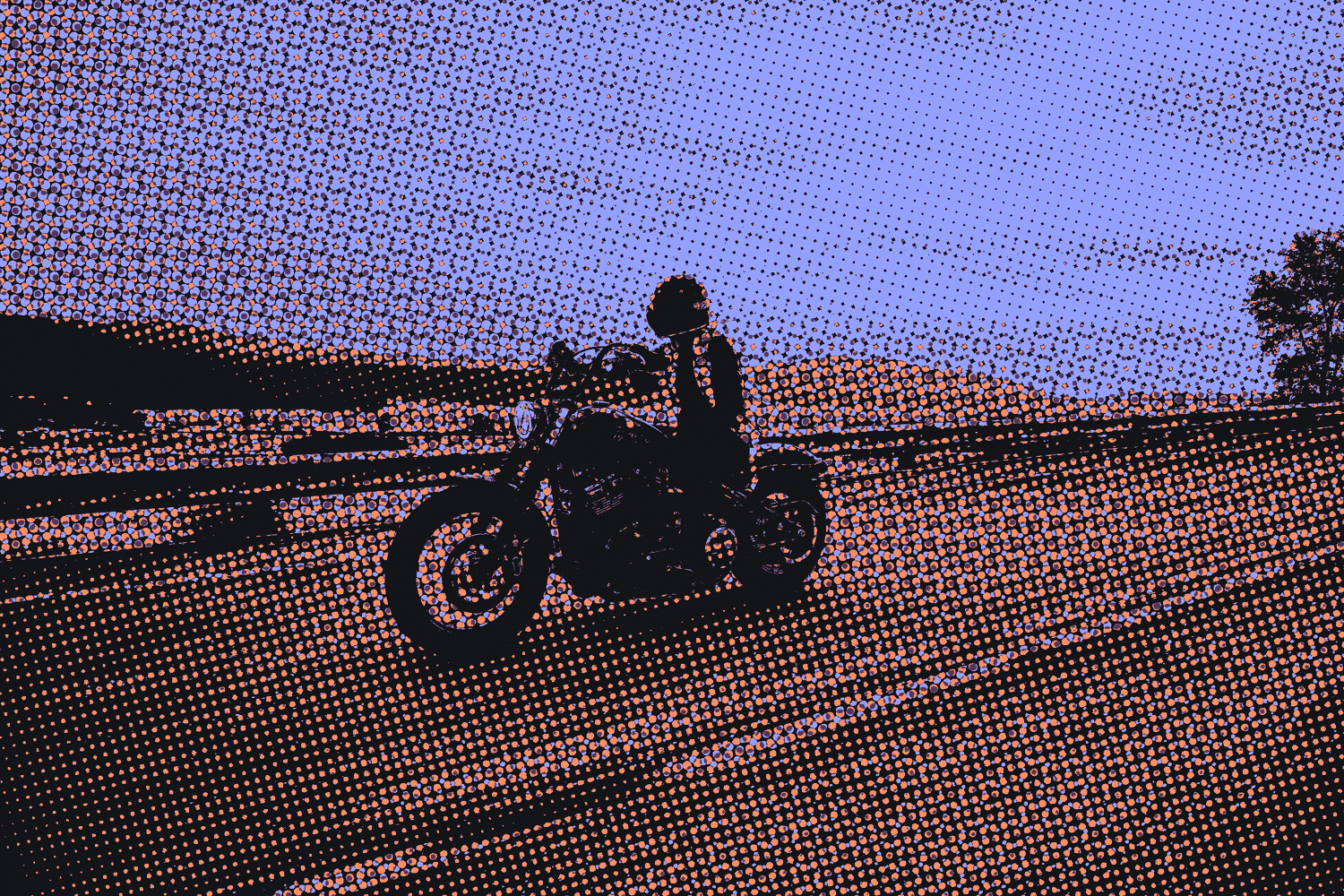 A rider on a motorcycle on an open road at sunset