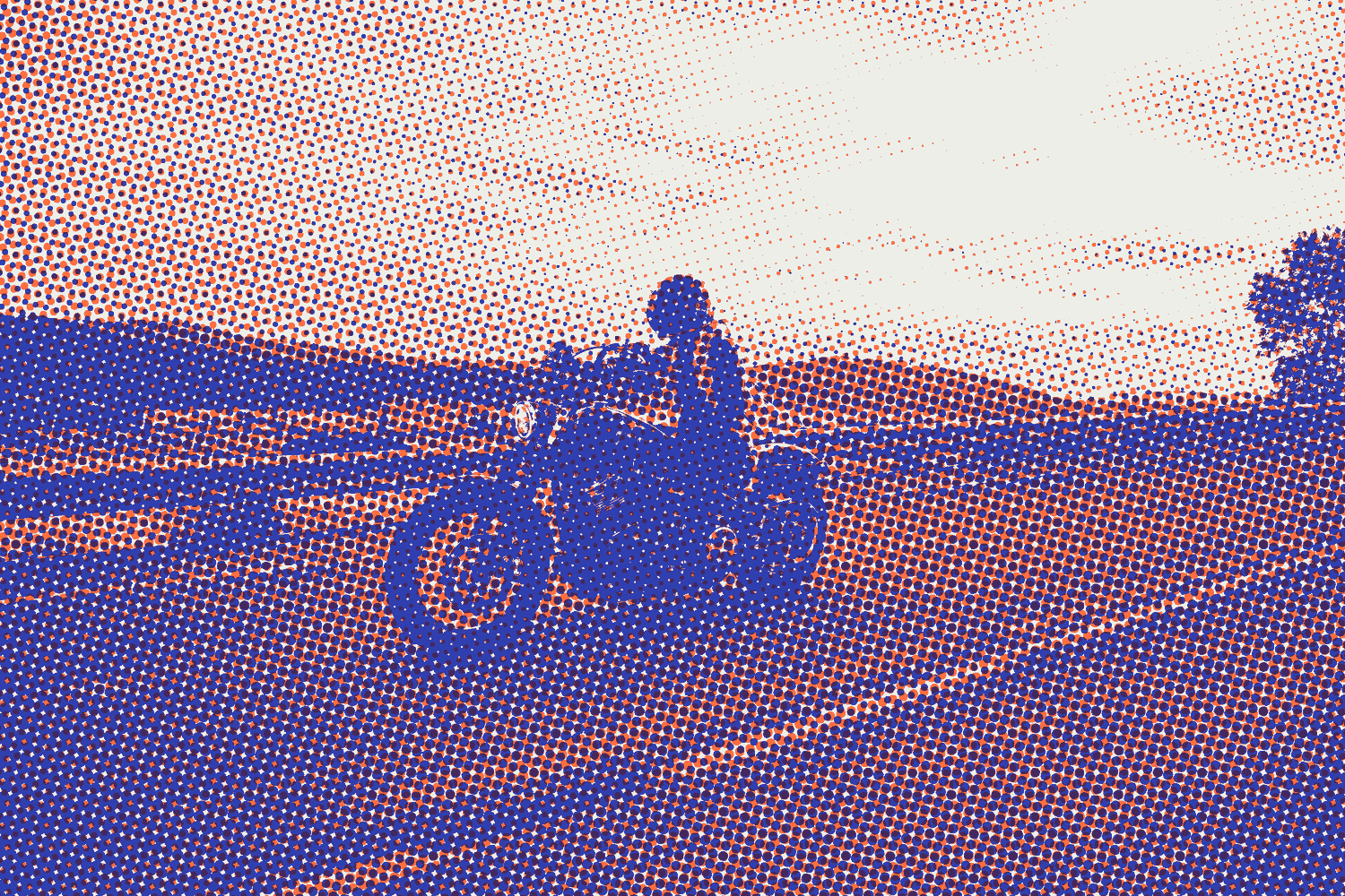 A rider on a motorcycle on an open road at sunset
